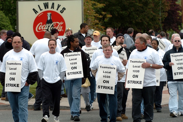 Coca-Cola soft drink production workers and delivery drivers walk a picket line outside the East Hartford, Conn., plant Monday. The workers walked out over the company's proposal that they pay more for health benefits.