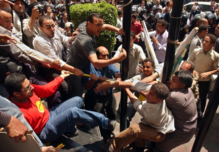Egyptian supporters from the ruling National Democratic party, right, fight Wednesday with supporters from the Kifaya movement, during a rally in Cairo. 