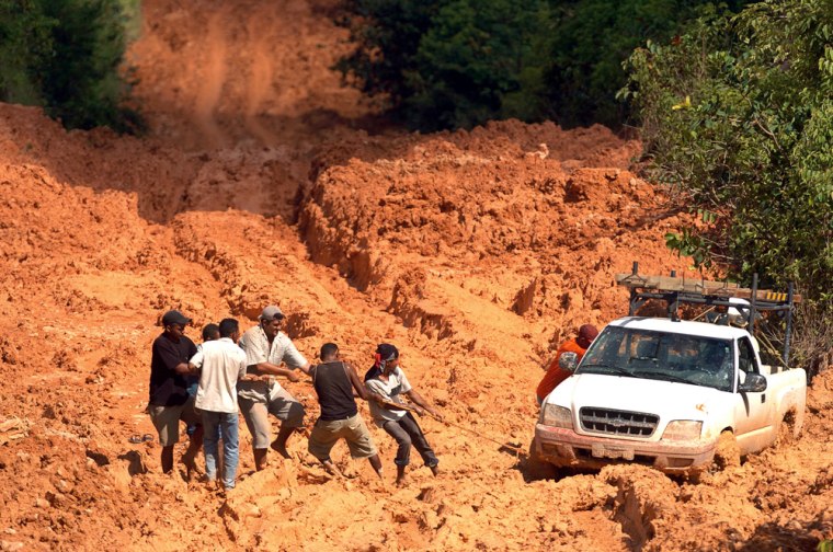 A pickup stuck in a muddy stretch of Brazil's BR163 highway reflects the battle over the Amazon. Settlers want to tame the forest by paving and clearing much of it, while environmentalists and Indians fear the development can't be sustained.