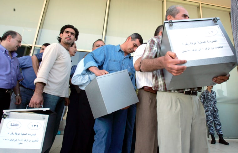 Lebanese civil servants carry ballot boxes to voting stations in Beirut on Saturday in preparation for the country's first elections since Syrian troops left in April after nearly three decades.