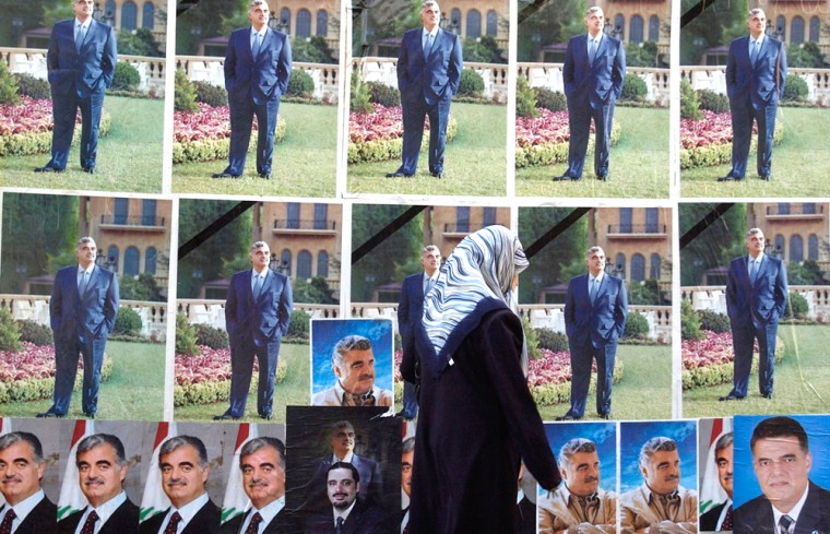 A woman walks by posters showing Lebanon's slain former Premier Rafik Hariri, in Beirut, Saturday, May 28, 2005, a day before Lebanon's parliamentary elections start. Hariri's assasination in Febuary sparked mass protests and was the catalyst for international pressure that forced Syria to withdraw its army from Lebanon. Lebanon's long-awaited legislative elections, which begin Sunday in Beirut and continue in other regions over the following three Sundays, are seen as a chance to end Syria's political dominance. (AP Photo/Darko Bandic)
