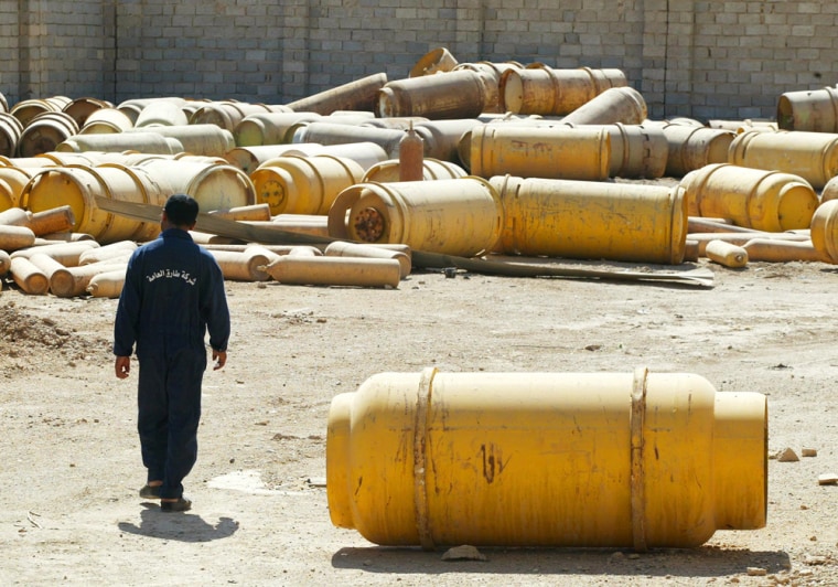 The security chief of Fallujah II chlorine plant, Mohammed Abid, walks among chlorine canisters in the plant's yard in Mulahimah, Iraq Thursday Oct. 2, 2003. Once the CIA's \"best example\" of a disguised weapons program, the derelict chemical plant stands today more as a symbol of the gap between fears and reality in the Iraqi crisis. (AP Photo/Greg Baker)