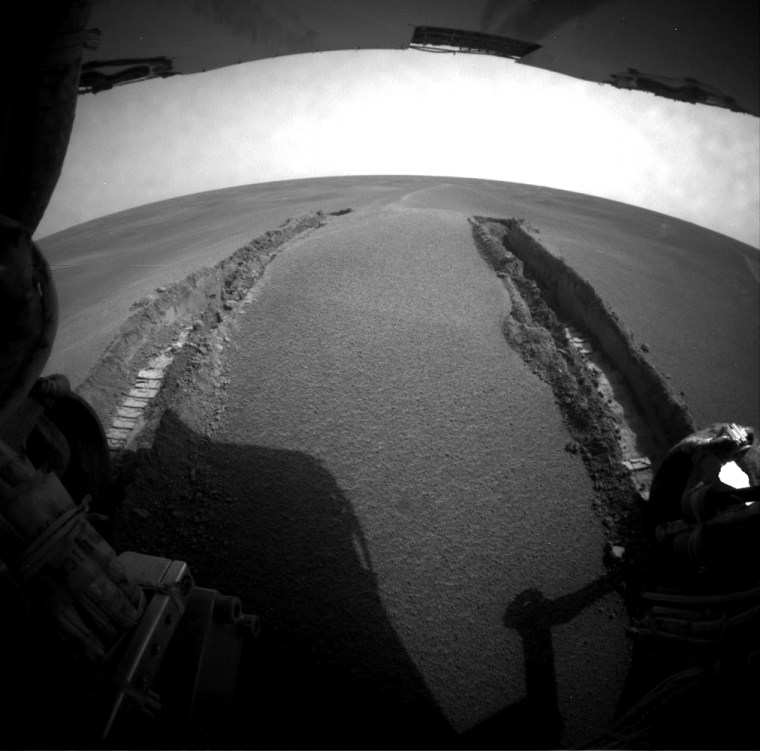 A view from one of the Opportunity rover's hazard avoidance cameras looks back at the deep ruts in the fine Martian soil left by the rover's wheels.