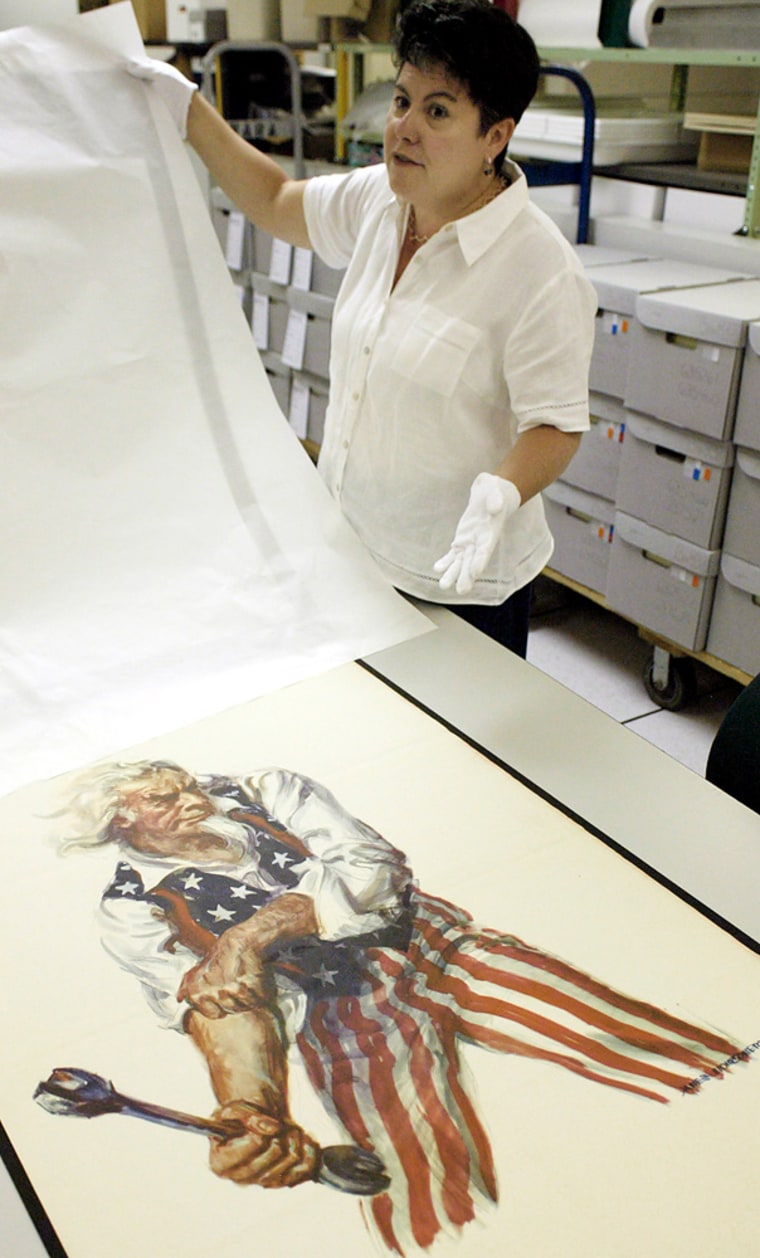 Marta O'Neill shows one of the World War I-era recruitment posters restored at the National Personnel Records Center in Overland, Mo. The National Archives opens 1.2 million military records and documents to the public for the first time on Saturday.