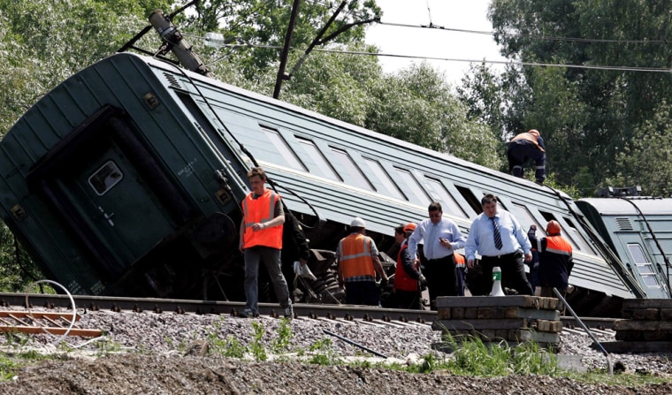 Russian specialists inspect the site of an explosion which derailed a passenger train some 150 km south of Moscow
