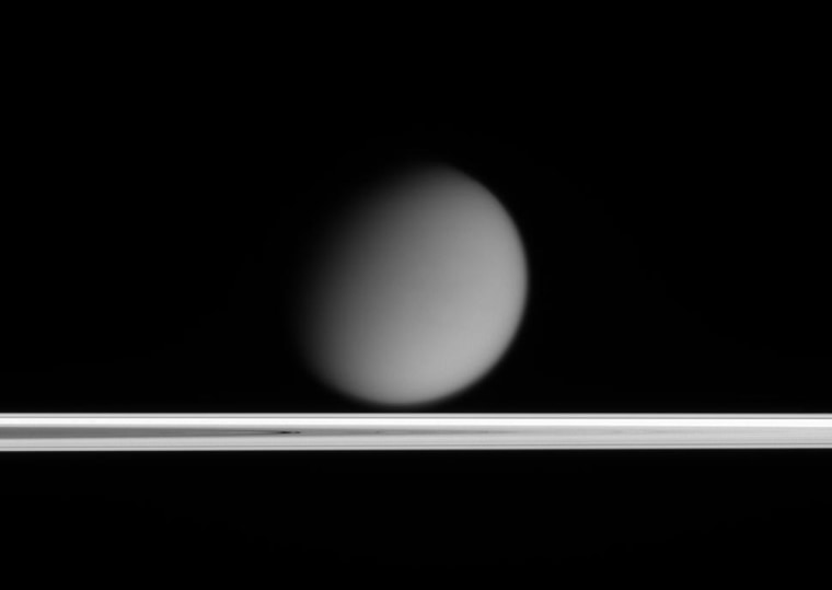 Saturn's hazy moon Titan appears to drift above Saturn's rings in this image taken by the Cassini spacecraft. The success of the mission has scientists thinking about where to go next.