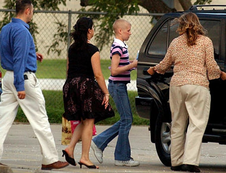 Katie Wernecke, 13, center, is escorted from the Nueces County Child Protective Services office in Corpus Christi, Texas, by office employees after a birthday party last Friday.