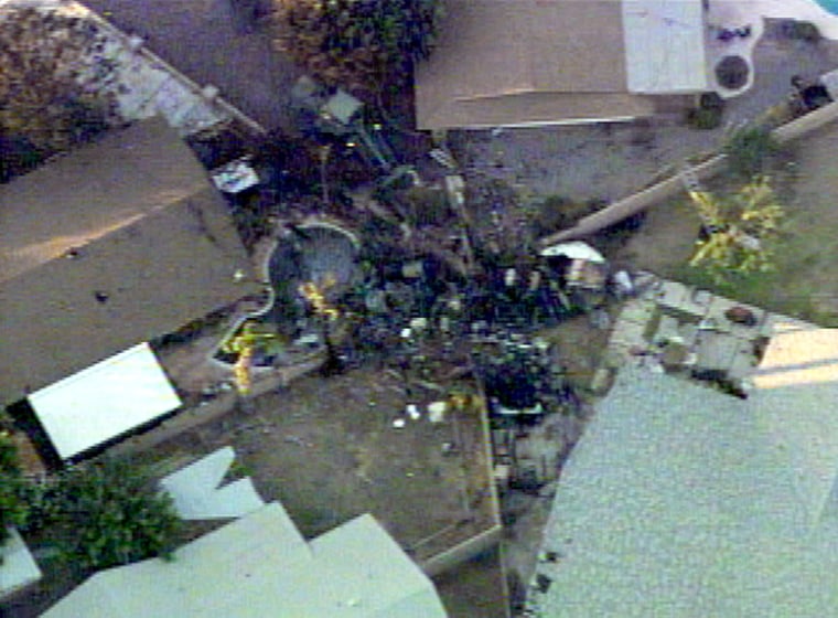 The wreckage of the Marine Harrier jet that crashed Wednesday in Yuma, Ariz., is seen between several homes.