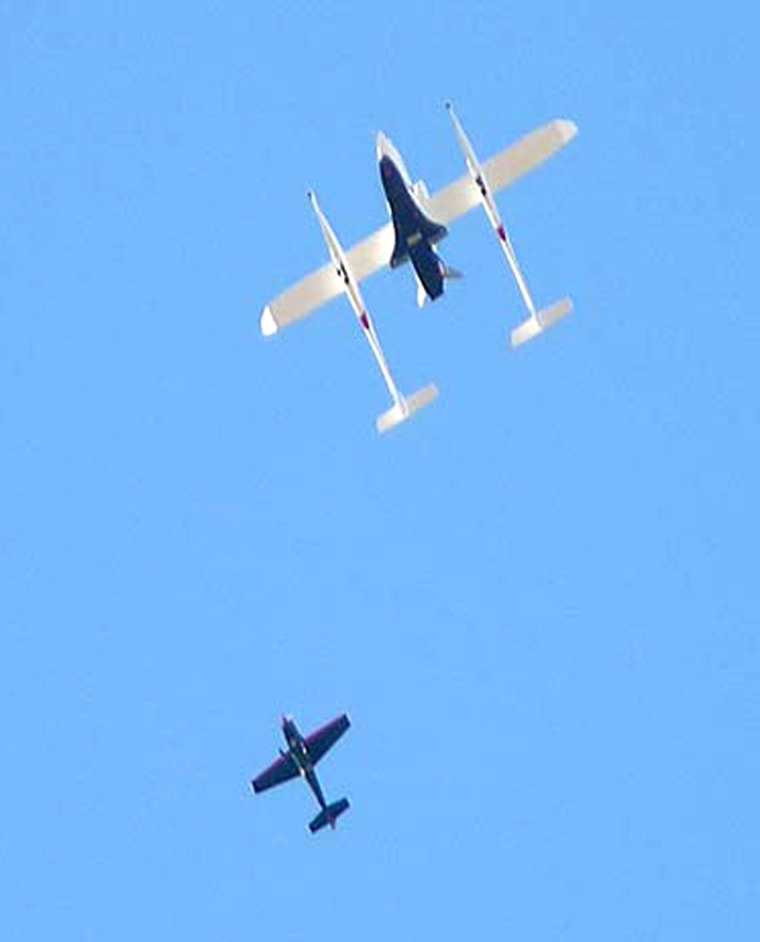 NASA's X-37 space plane is carried underneath the White Knight as a chase plane looks on above the Mojave desert Tuesday.