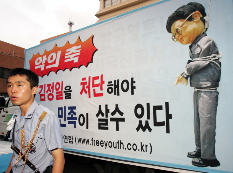 Policeman stands guard beside placards denouncing North Korean leader in Seoul