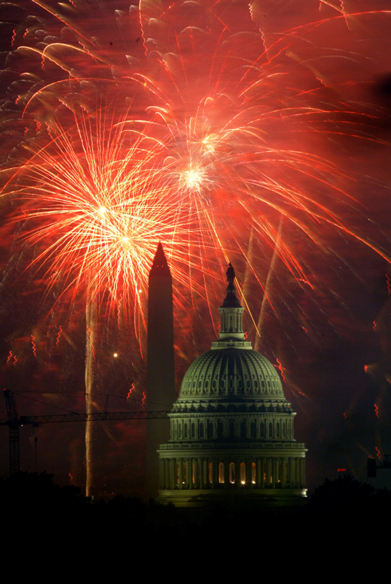 Fourth of July fireworks explode in the sky behind the U.S. Capitol and Washington Monument, in Washington D.C.