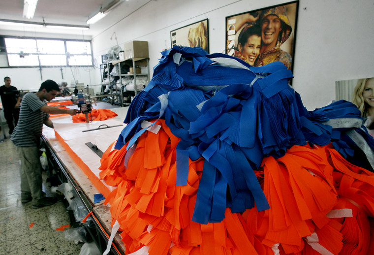 A textile factory near Tel Aviv, Israel, turns out orange and blue ribbons on Monday. The orange ribbons are symbols of the Jewish settlers and the blue ones are used by peace activists.