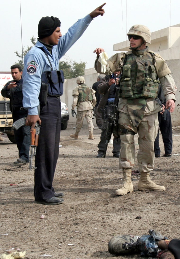An Iraqi police officer and a U.S. soldier argue over collecting remains of a suicide bomber on Jan. 30, 2005. Suicide attackers are overwhelmingly foreigners who sneak through the Iraqi border, some as young as 15. 