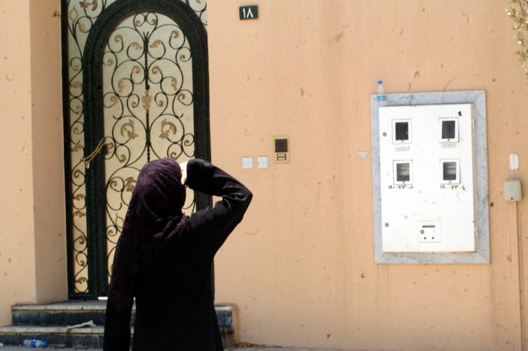 Female  journalist looks at building where militant was killed in Riyadh