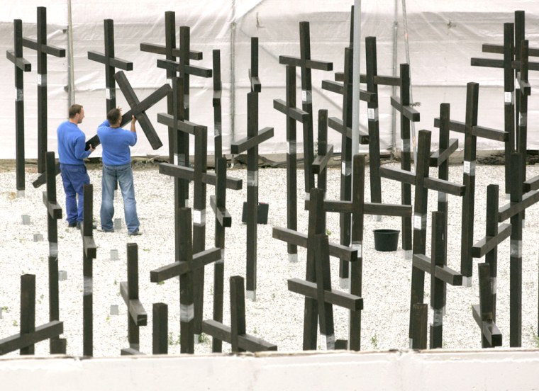 Workers tear down the crosses of the private Wall memorial near the former allied Checkpoint Charlie in Berlin, Germany, on Tuesday.