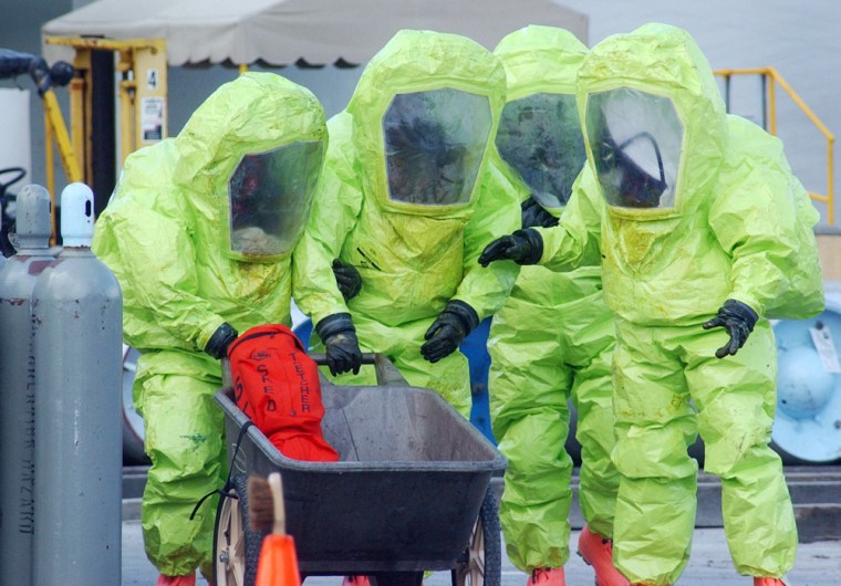 In a March 2004 file photo, Miami-Dade Fire Rescue hazardous material technicians walk to a decontamination area after sealing a leaking chlorine cylinder at a company in Miami. Chemical plants in several states are located in population centers of at least 1 million people, according to a congressional report to be released Wednesday.