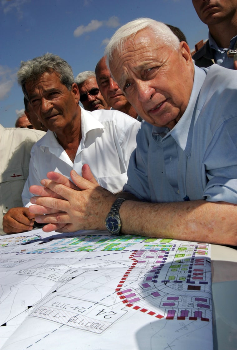 Israeli Prime Minister Ariel Sharon, right, discusses plans Tuesday with contractors who are building temporary housing for settlers due to be evacuated from the Gaza Strip.