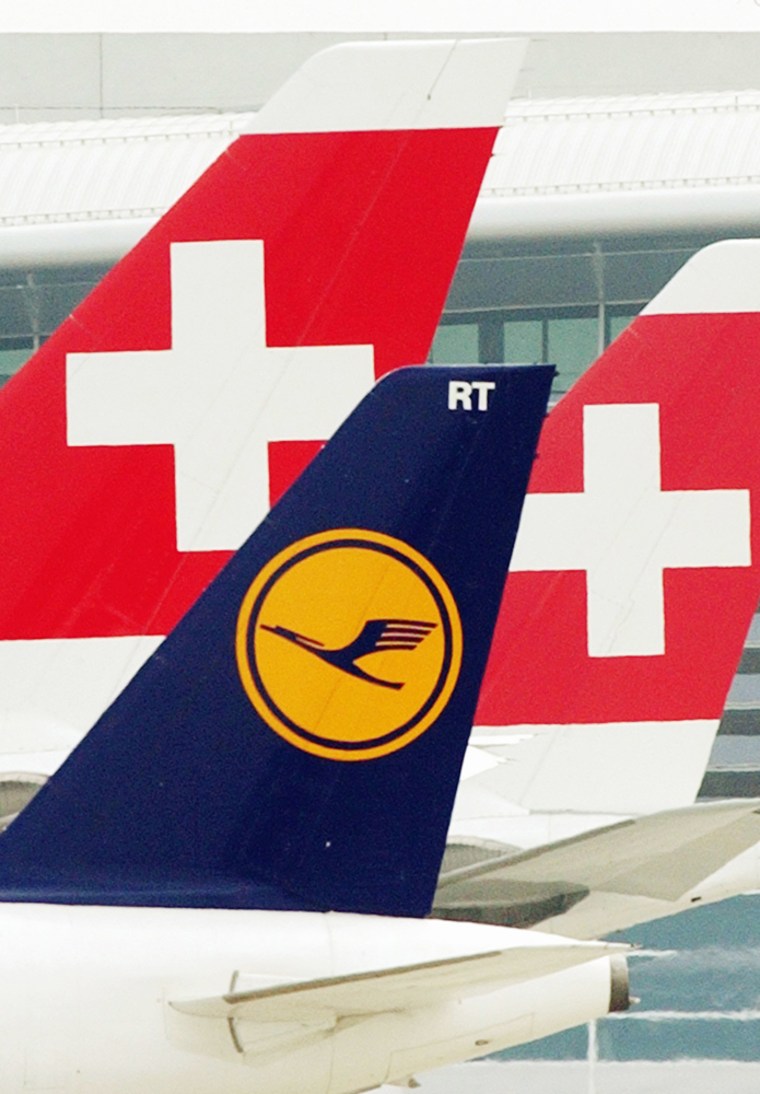 The tails of a German Lufthansa plane, front, and two planes of Swiss airline Swiss International are seen at Zurich airport. Lufthansa won EU approval Tuesday for its $374.7 million takeover of Swiss International.