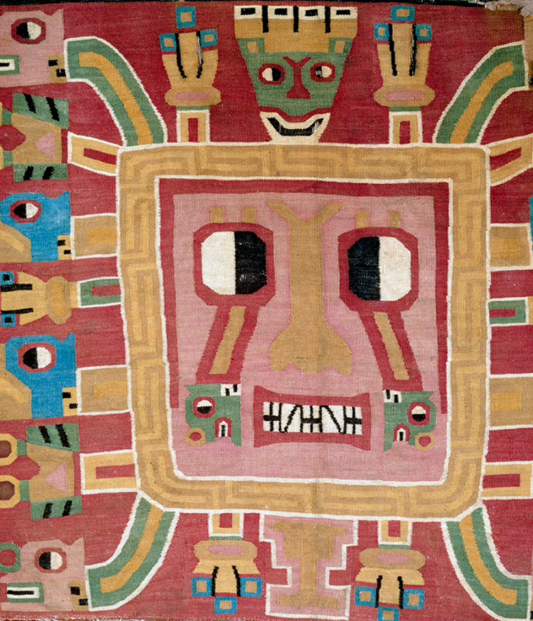 This image shows a fragment from a Huari-style ceremonial panel from Peru, dating from A.D. 750 to 800. The tapestry shows a fierce-looking deity with rays coming out of his head.