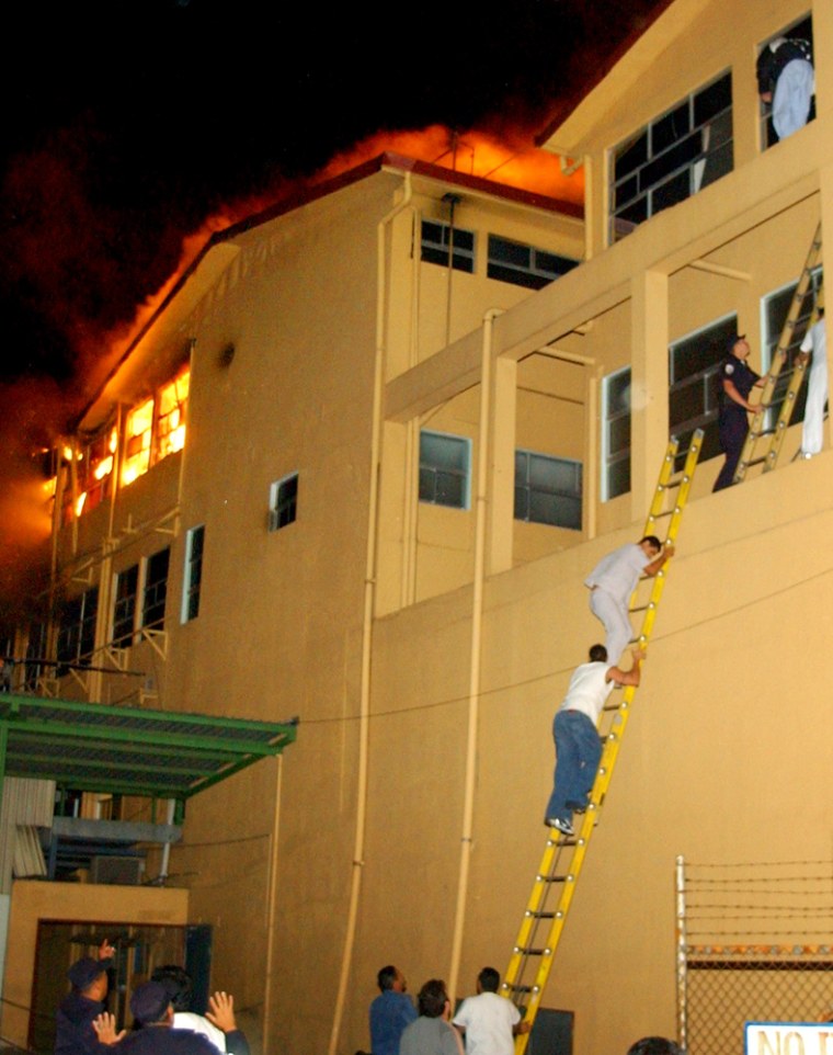 Costa Rican firefighters help evacuate patients from a fire at the Caleron Guardia Hospital in San Jose, Costa Rica, on Tuesday.