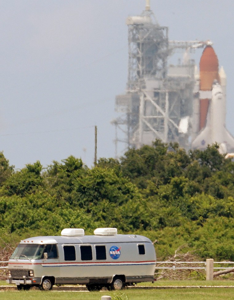 Discovery's crew is driven away from the launch pad at Kennedy Space Center after after their scheduled schuttle launch was scrubbed Wednesday. The seven astronauts were strapped into their seats in the shuttle when the launch was postponed.