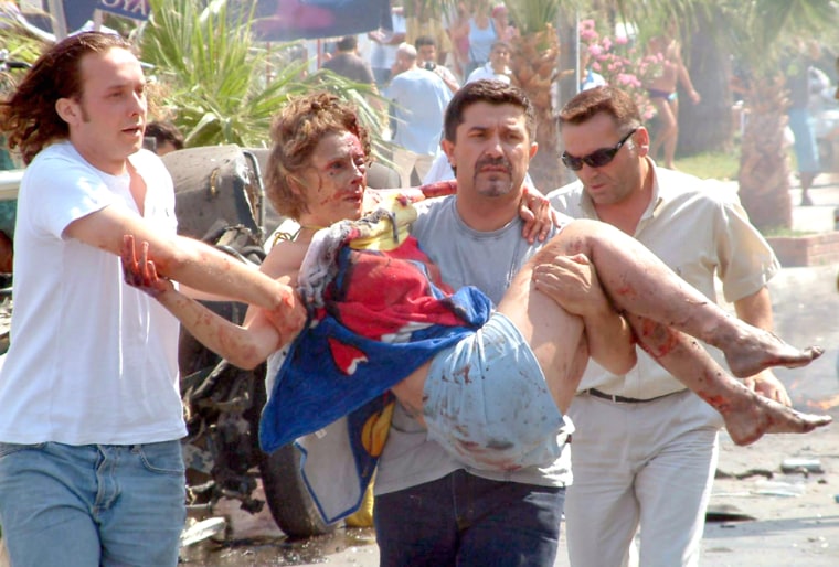An injured woman is helped after explosion in Turkish resort town of Kusadasi