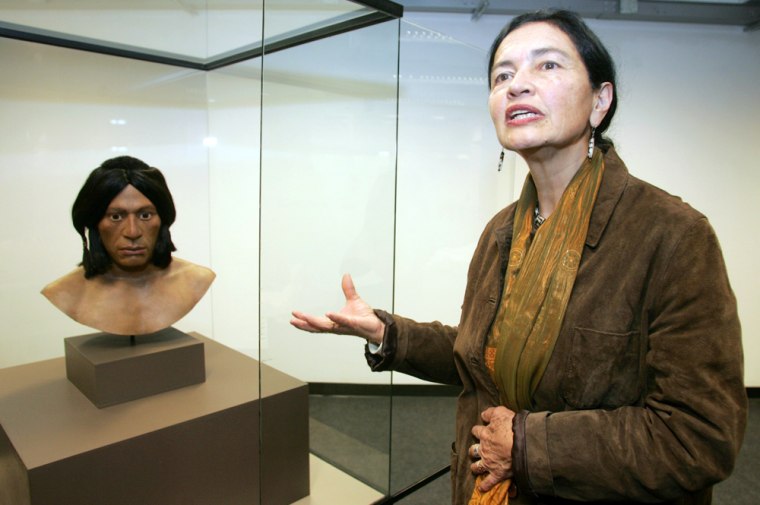 Peruvian archaeologist Ruth Shady shows a clay figurine during an exhibition at the National Museum in Lima