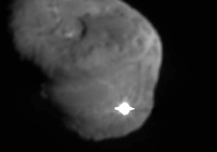 A newly released photo from NASA's Deep Impact mothership shows the first flash from the impactor probe's collision with Comet Tempel 1, which looks like a dark, pitted potato.