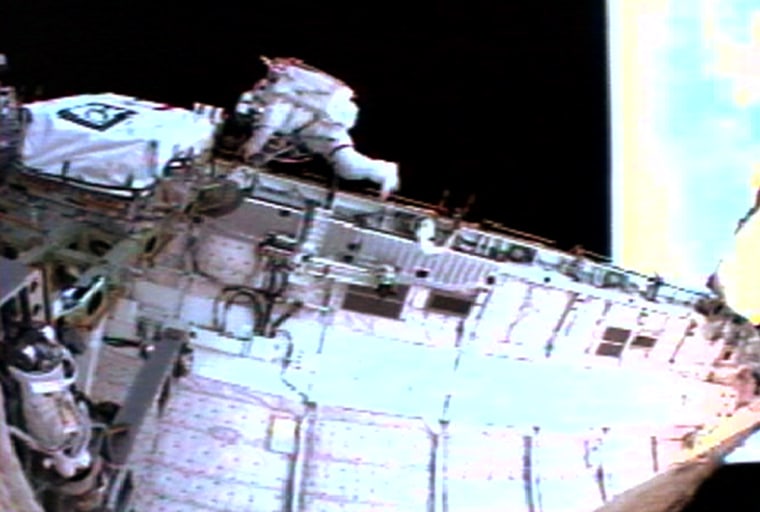 Soichi Noguchi of Japan makes his way along the sill of the payload bay during his spacewalk