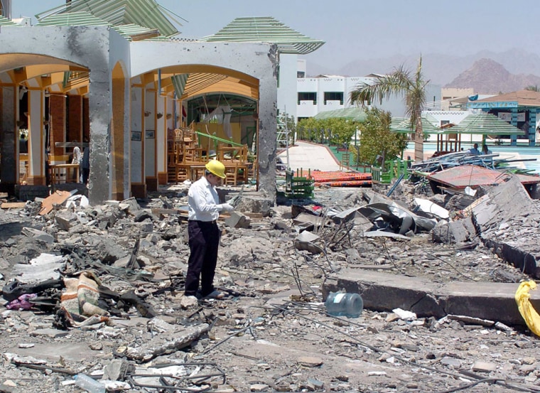 A forensic expert sorts out rubble in the remains of the Ghalaza hotel
