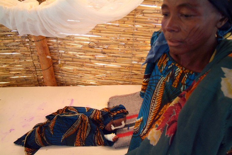 An unidentified mother stands near her dying child, who was said by local officials at the feeding centre, to have died hours later, at the MSF intensive care centre in Maradi, Niger, Friday, Aug. 5, 2005. The United Nations appealed on Friday for US$80 million (euro64.59 million) to fight a food crisis threatening the lives of thousands in this impoverished West African nation. Niger is the second poorest country in the world, with 64 percent of the 12 millions inhabitants surviving on less than US$1 (81 euro cents) day. Current shortages have seen food prices mount beyond what most here can pay.   (AP Photo/George Osodi)