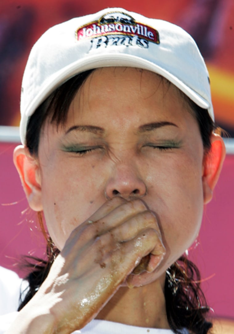 Sonya Thomas winces Saturday as she eats a bratwurst at a brat-eating contest in Sheboygan, Wis. 