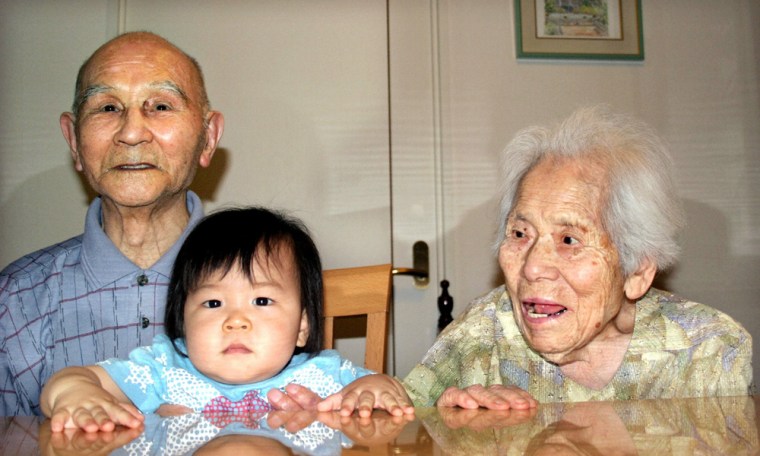 Japanese couple Yoichi and Kazono Gomi, who plan to claim title of world's oldest couple, pose in Yokohama, Japan