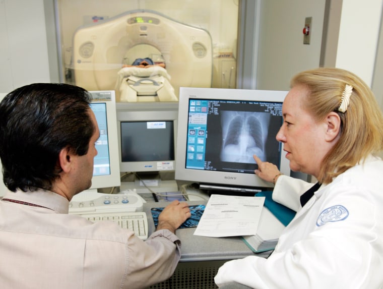 Dr. Claudia Henschke, chief of the division of chest imaging, and CT scan supervisor Gus Daphnis look at the lung scan of Patricia Dowds, background center, at New York Hospital - Cornell Medical Center in New York. 
