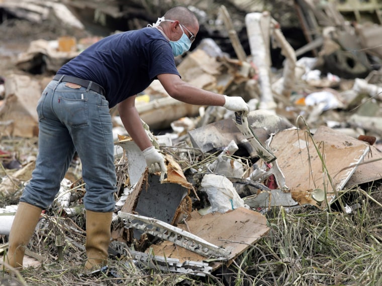 A rescue worker searches among the wreckage of West Caribbean Airways MD-82 aircraft in Machiques