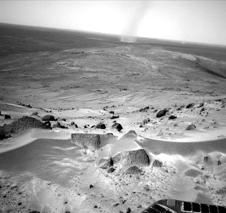 NASA's Spirit rover has rolled into position for a grand view atop Husband Hill on Mars. Dust devils scoot across the landscape in the background.