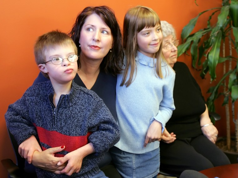 Emily B., second from left, holds her twins Ry, and Kaia, 7, with her mother Jeanne on Monday. Emily B.'s former partner was was ordered to pay child support.