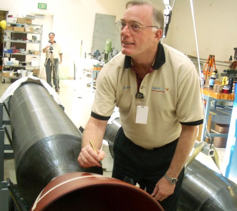 SpaceDev founder Jim Benson writes an inscription on a rocket motor for the SpaceShipOne craft in 2004. Benson's company helped develop the motors for the world's first manned, privately funded, reusable spaceship.