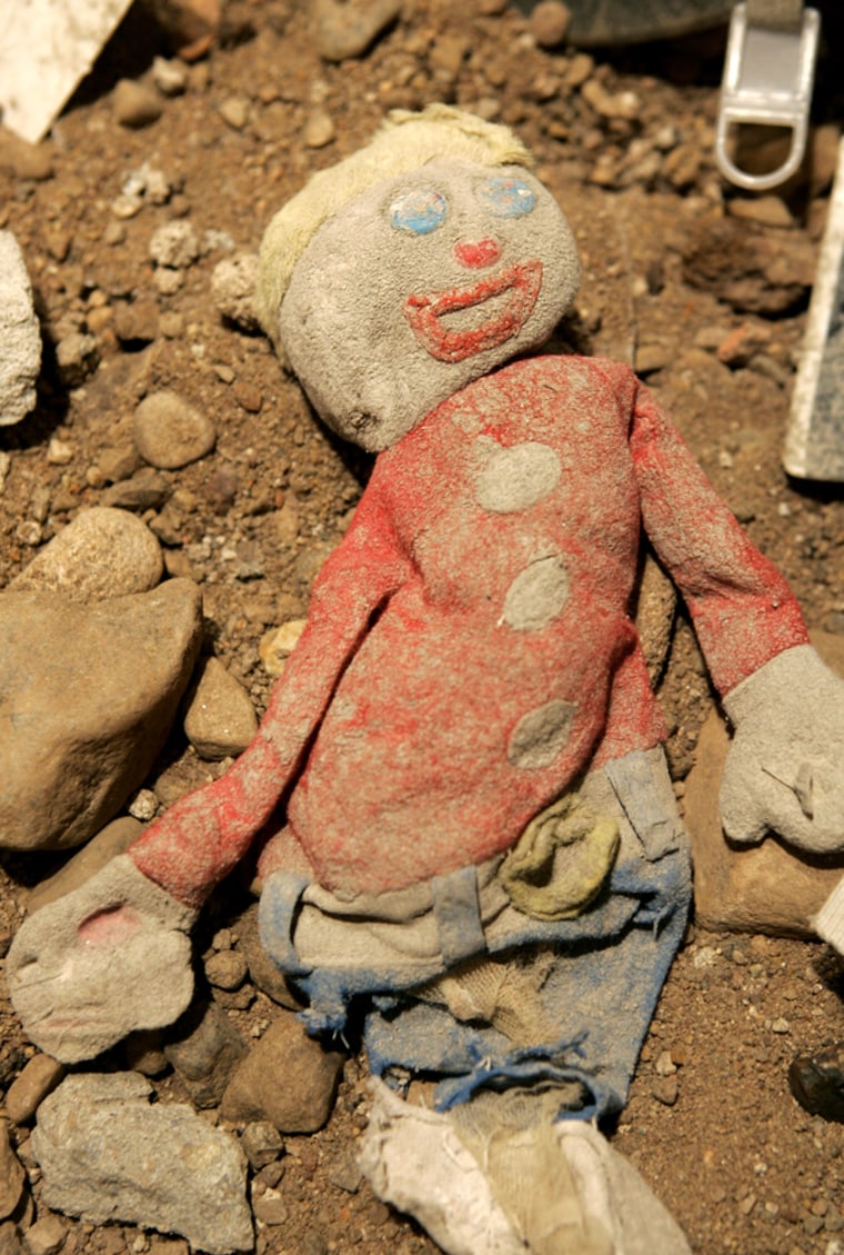 An ash-covered rag doll lies in debris from the World Trade Center site, Thursday, Aug. 25, 2005, at the Ground Zero Museum Workshop in New York. The doll is one of hundreds of artifacts collected by firefighters and actor/photographer Gary Marlon Suson, who is opening the museum dedicated to the World Trade Center recovery effort on Sept. 7, just days before the anniversary of the Sept. 11 attacks.  AP Photo/Kathy Willens)
