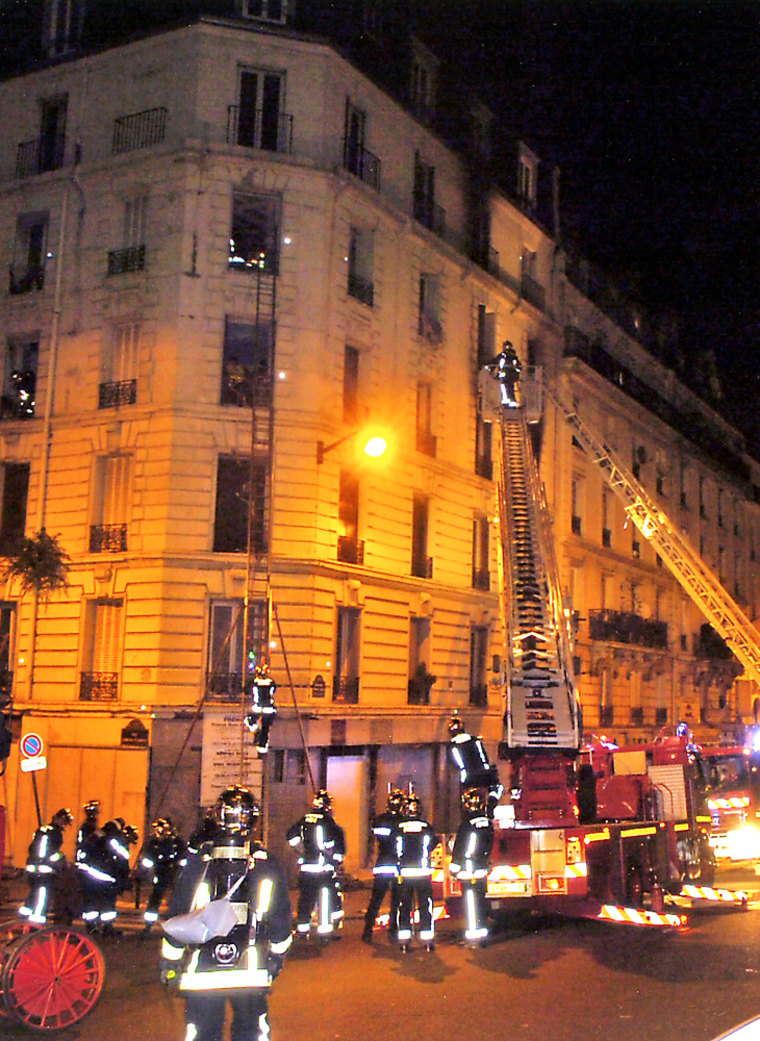 Rescue services attend the scene of fire in which 17 died in central Paris