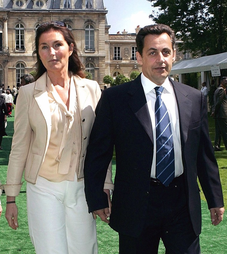 French Interior Minister Nicolas Sarkozy and his wife Cecilia walk together during a garden party at the Elysee Palace in Paris, in this July 2004 file photo. Once seen as France's ultimate power couple, their relationship is on the rocks and France can read all about it, in the usually restrained press.