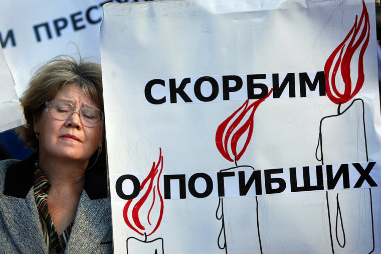 A demonstrator stands at a poster reading "We Mourn the Killed," during a demonstration in Moscow on Friday marking the one year anniversary of the Beslan school seizure.