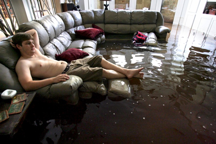 Resident sits on a couch in his flooded living room in Metairie, outside New Orleans