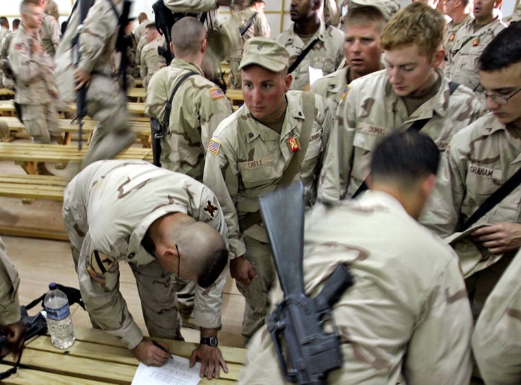 Members of the 256th Brigade Combat of the Louisiana National Guard fill out papers about the status of their homes and families in Louisiana during a briefing at Camp Victory, on the Iraqi-Kuwait border, on Wednesday.