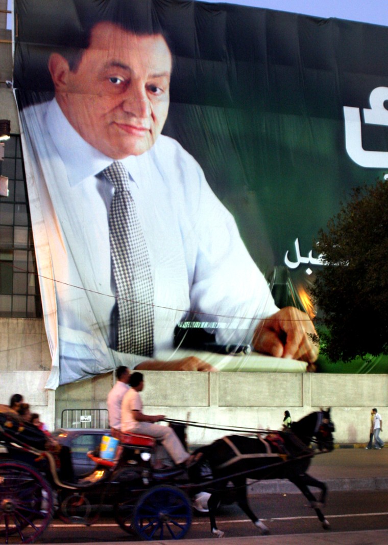 Tourists in Cairo pass a giant election poster of Hosni Mubarak, who on Friday was officially declared the winner of Egypt's first contested presidential election.