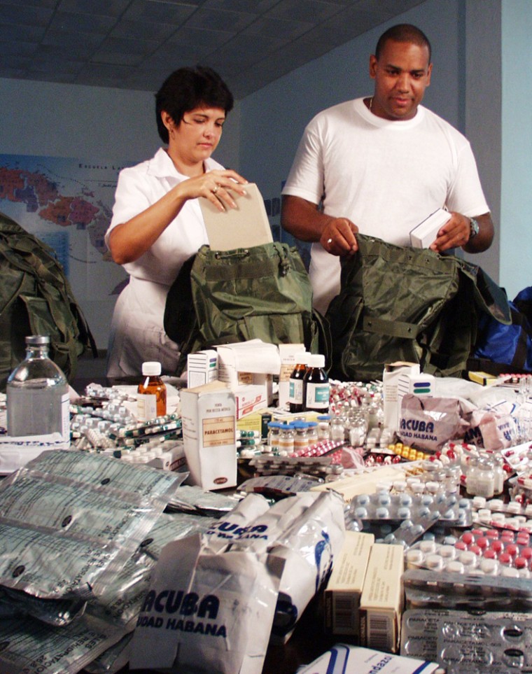 Although it is unlikely they will be going anywhere, Havana doctors Luis Sauchay and Delvis Marta Fernandez prepare their knapsacks of emergency medical supplies for Katrina victims. 