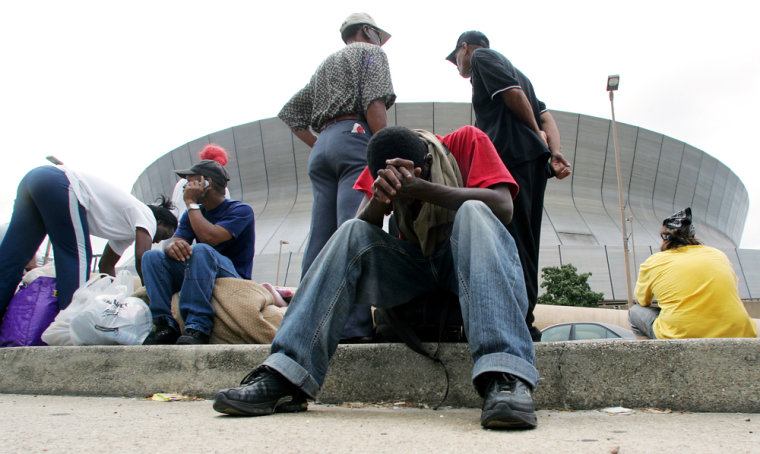 David Riley sits with his head in his hands as he waits with hundreds of others outside the Louisiana Superdome in New Orleans on Sunday, Aug. 28.
