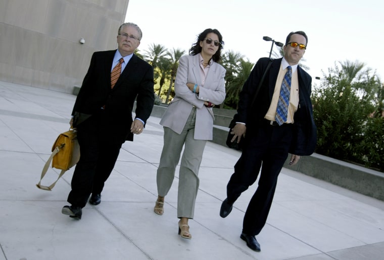 Heather Catherine Tallchief, center, flanked by her attorneys Daniel J. Albregts, right, and Robert M. Axelrod, turns herself in to authorities at U.S. District Court in downtown Las Vegas on Thursday Sept. 15, 2005. Tallcheif turned herself in after 12 years on the FBI's most wanted list for a $3.1 million Las Vegas Strip casino armored truck heist. (AP Photo/Isaac Brekken)