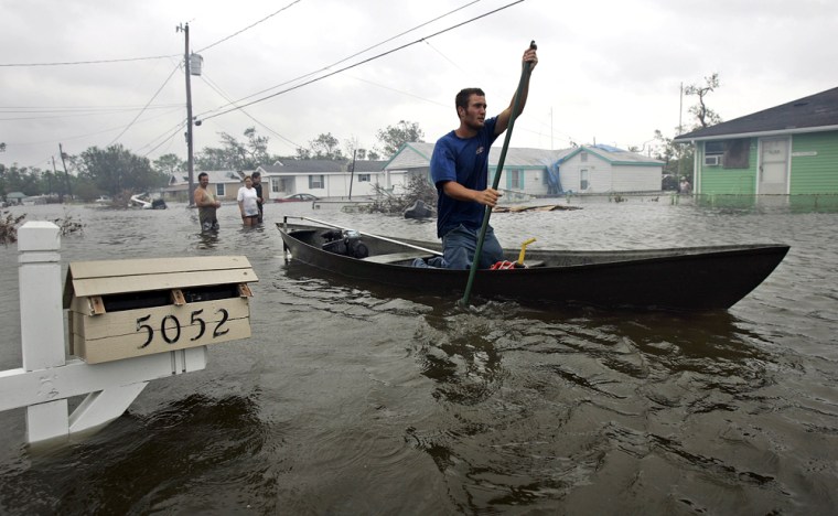 Kyle Guidry paddles up a street in Laffite, La., to check on his house after surges from Hurricane Rita flooded the area on Saturday.