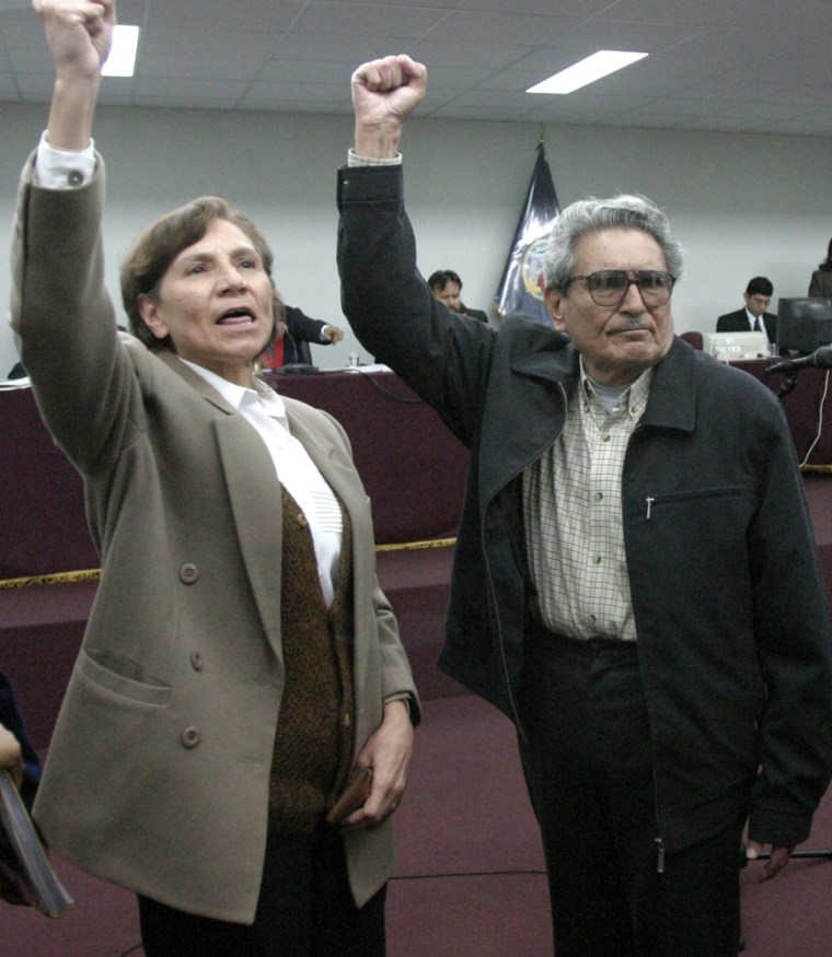 Abimael Guzman, the founder of Peru’s Shining Path guerrilla movement, right, and Elena Iparraguirre, his cellmate and longtime aide and lover, raise their arms at Guzman's trial in this November 2004 file photo. The proceeding ended in a a chaotic mistrial.
